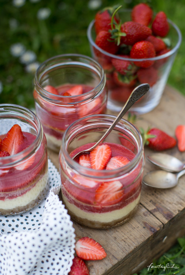 Kleine Erdbeer-Cheesecakes im Glas mit knusprigem Boden, Erdbeerpüree ...
