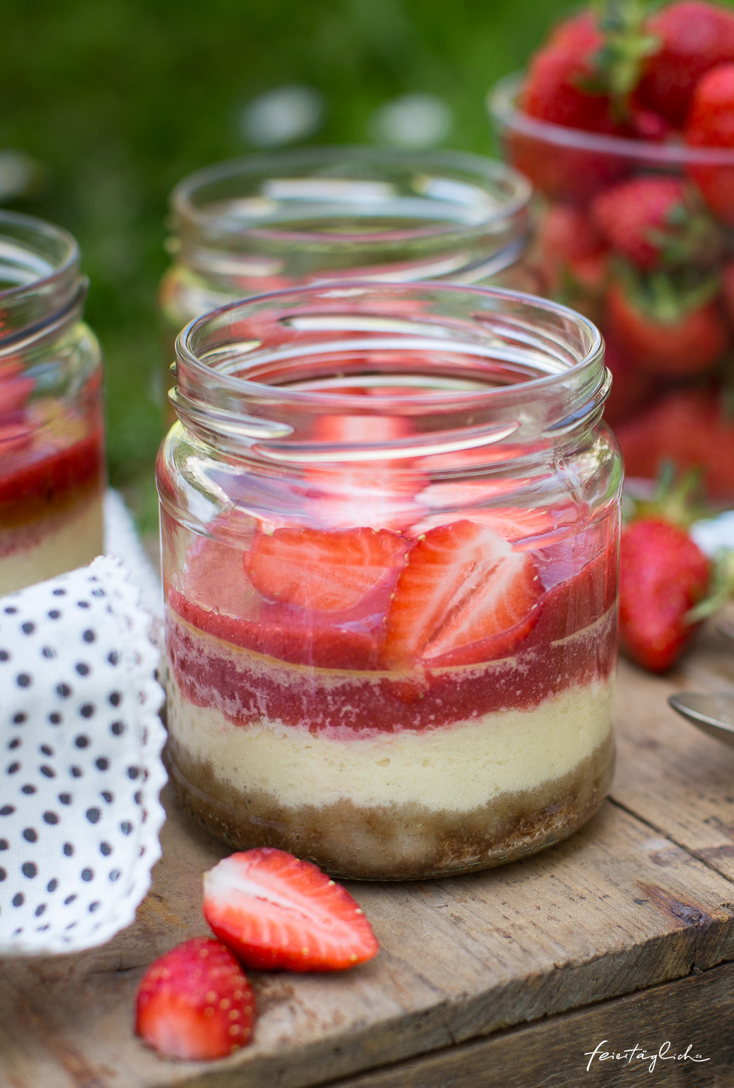 Picknickrezept: Kleine Erdbeer-Cheesecakes im Glas mit knusprigem Boden, Erdbeerpüree und frischen Erdbeeren, Meal-Prep-Dessert