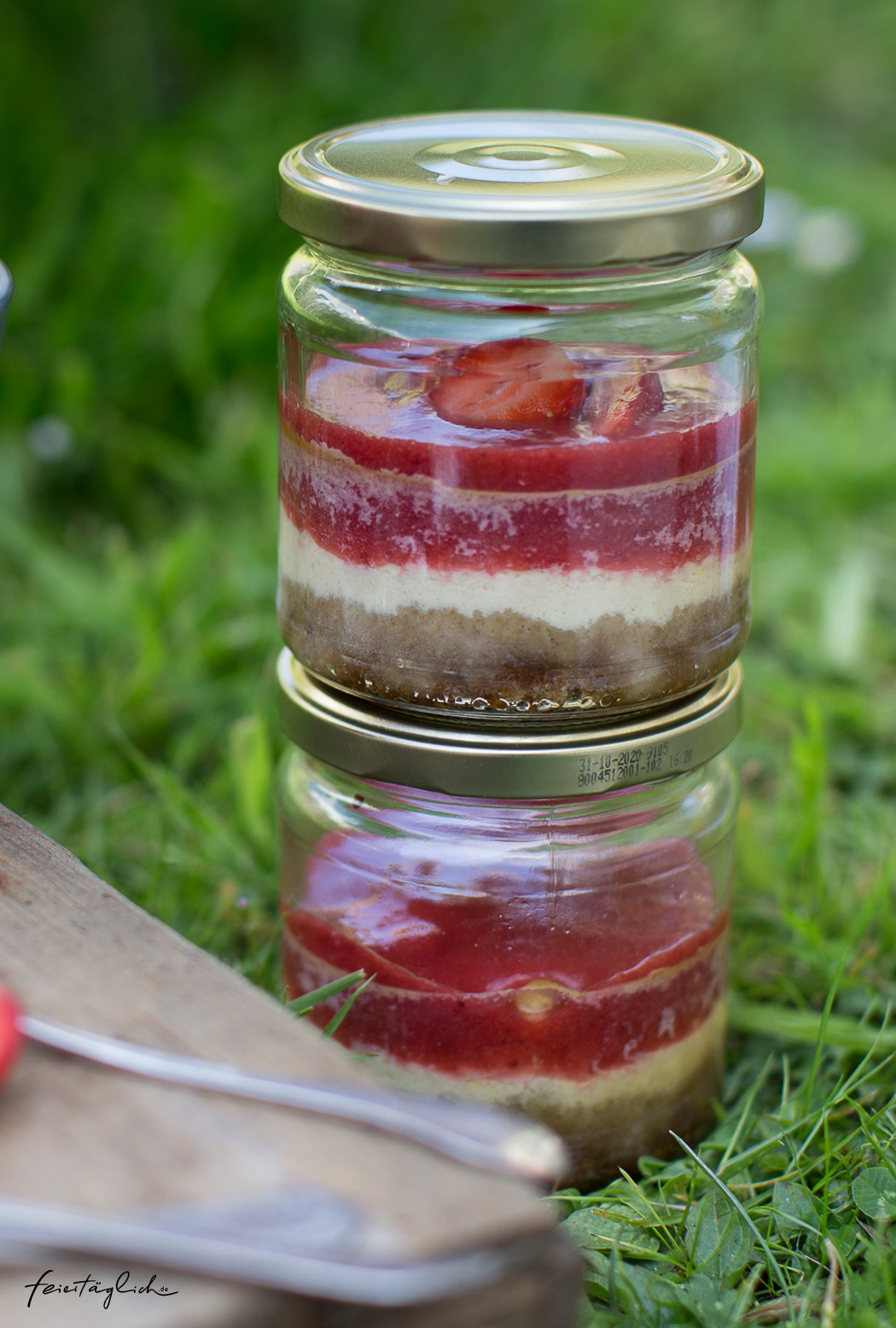 Picknickrezept: Kleine Erdbeer-Cheesecakes im Glas mit knusprigem Boden, Erdbeerpüree und frischen Erdbeeren, Meal-Prep-Dessert
